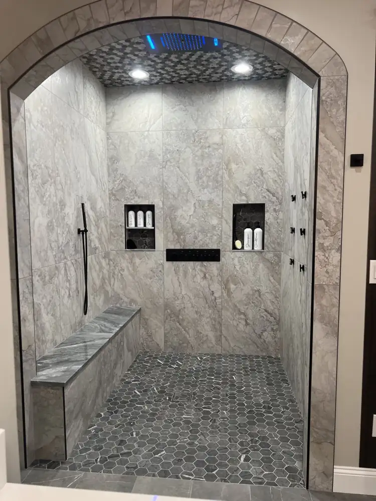 Arched curbless shower with LED rain head, body jets, bench and hex mosaic floor, Avon Lake, Ohio
