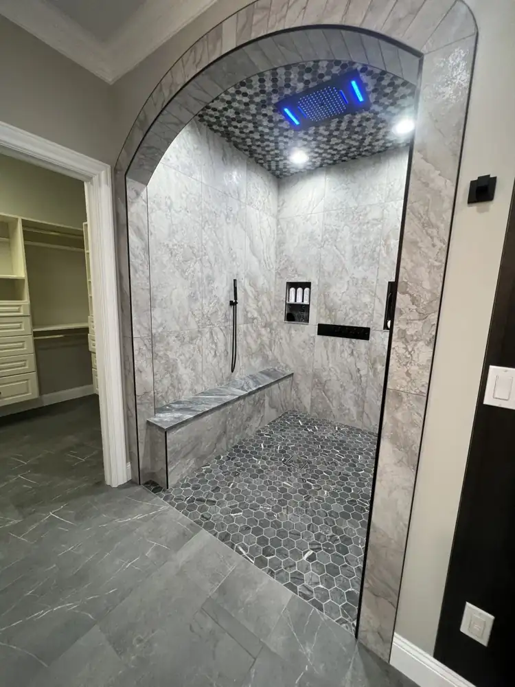 Another view: Arched curbless shower with LED rain head, body jets, bench and hex mosaic floor, Avon Lake, Ohio