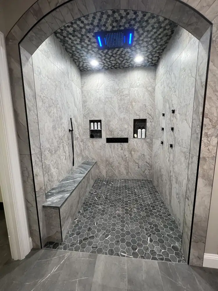 Another view: Arched curbless shower with LED rain head, body jets, bench and hex mosaic floor, Avon Lake, Ohio