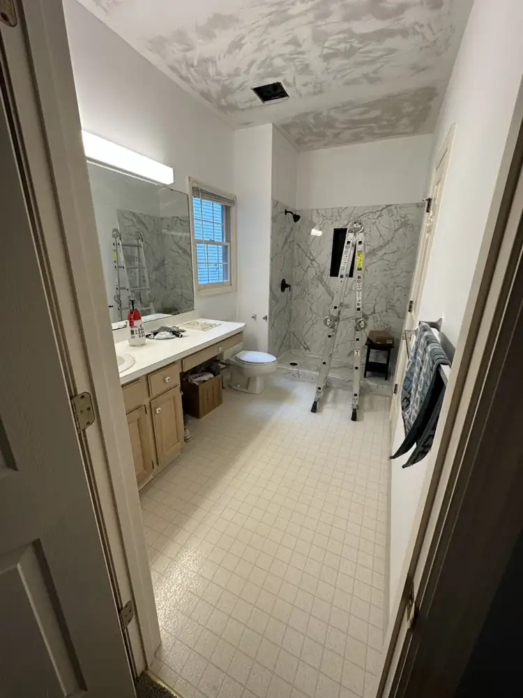 Primary bathroom with oak vanity and vinyl floor during remodel, Aurora, Ohio