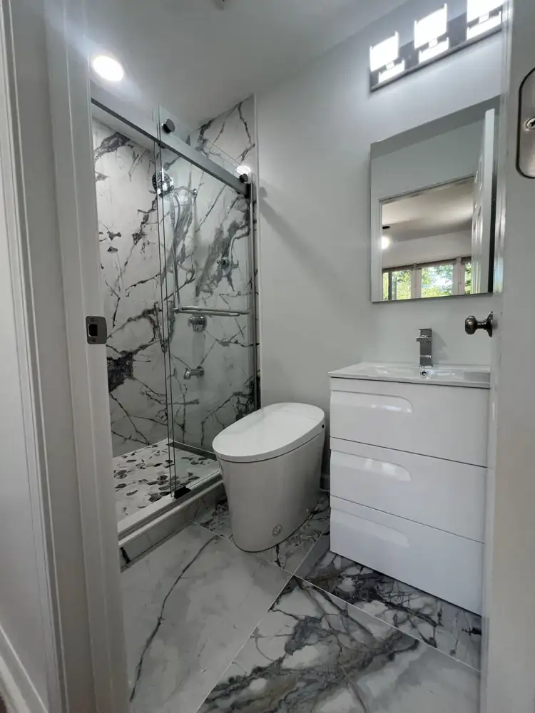Compact new bathroom with large-format marble-look porcelain, glass shower, smart toilet and floating white vanity, Aurora, Ohio