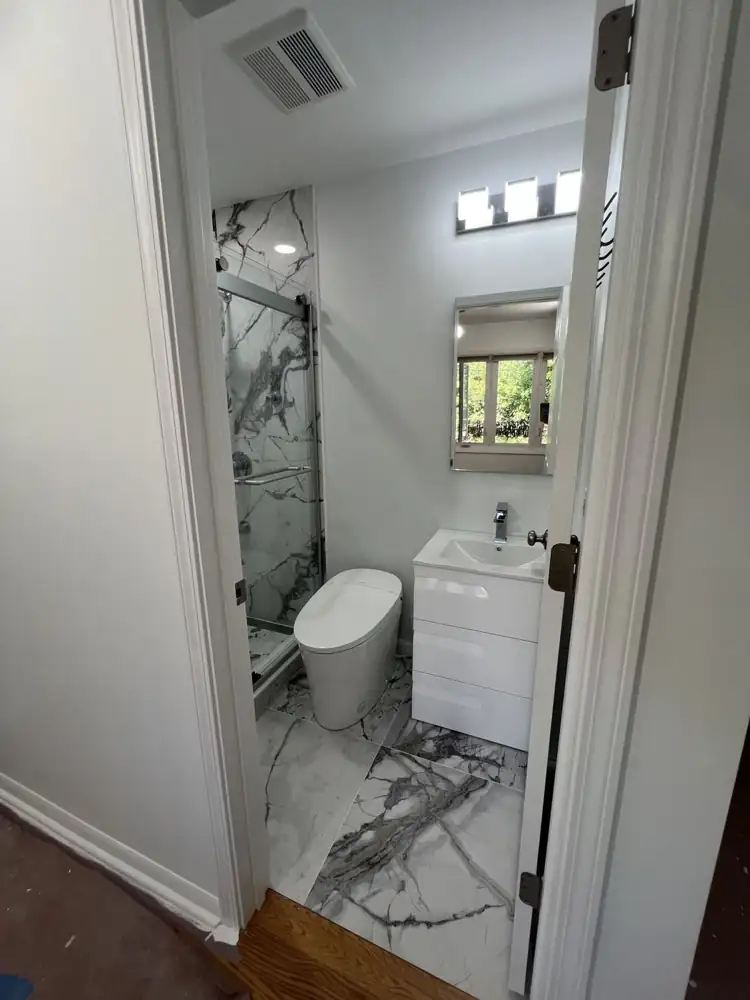 Another view: Compact new bathroom with large-format marble-look porcelain, glass shower, smart toilet and floating white vanity, Aurora, Ohio