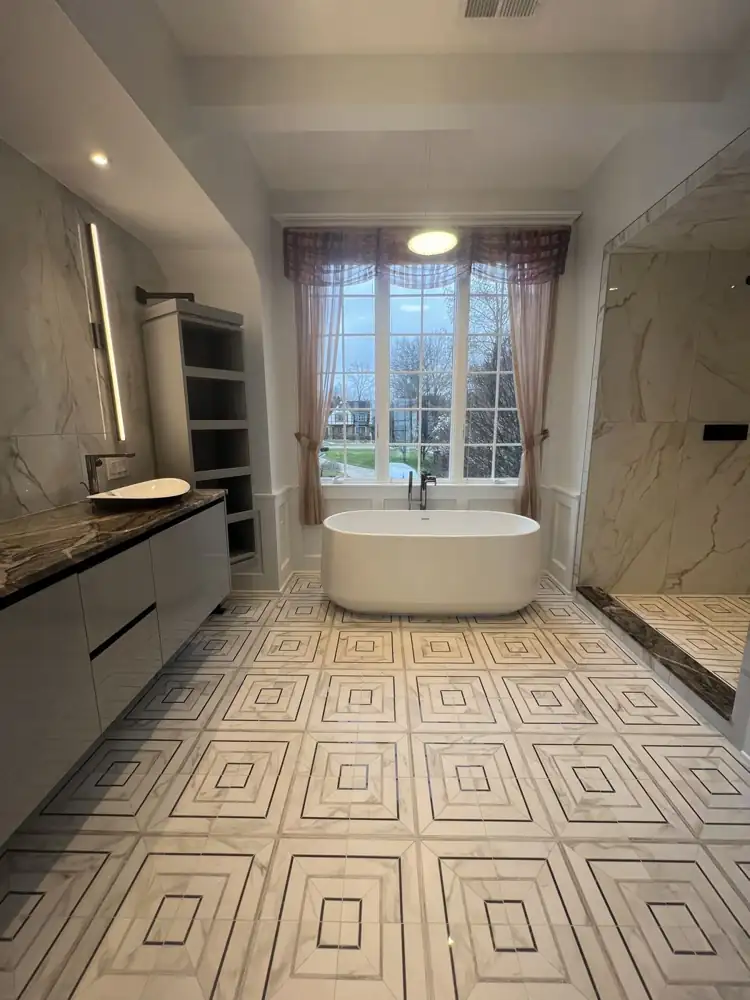 Freestanding tub under window, geometric marble-look mosaic floor, floating vanity with vessel sink, Bay Village, Ohio