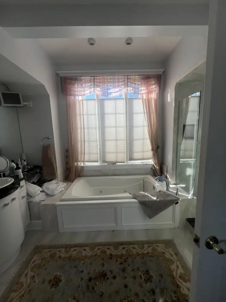 Primary bathroom with drop-in jetted tub under a window before remodel, Bay Village, Ohio