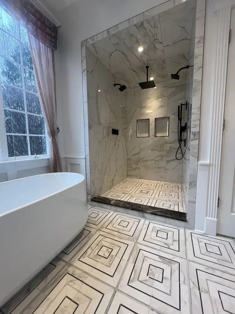 Another view: Freestanding tub under window, geometric marble-look mosaic floor, floating vanity with vessel sink, Bay Village, Ohio