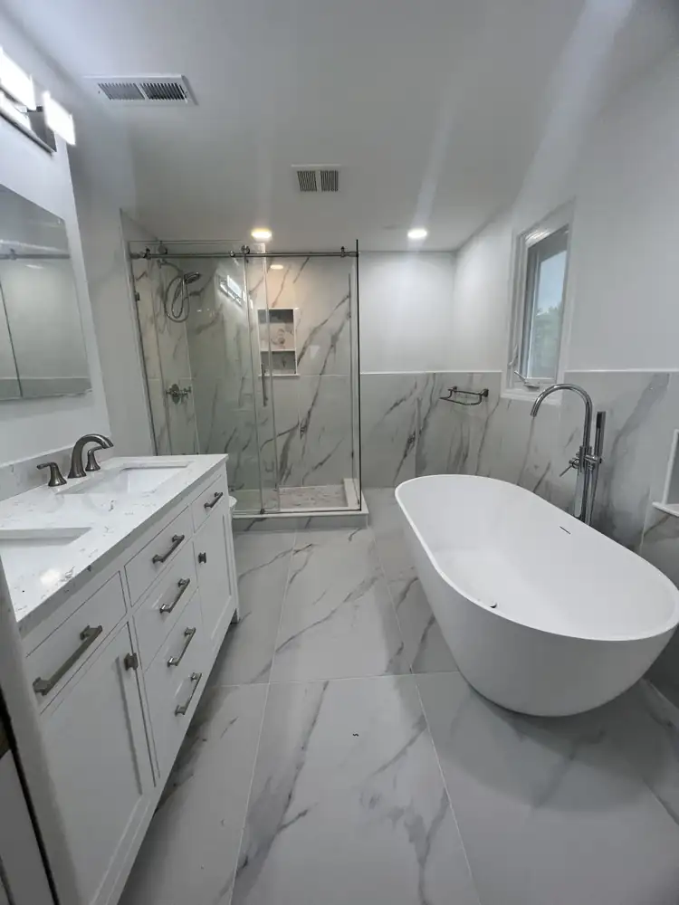 Primary bathroom with freestanding tub, glass shower, double vanity and marble-look porcelain, Beachwood, Ohio