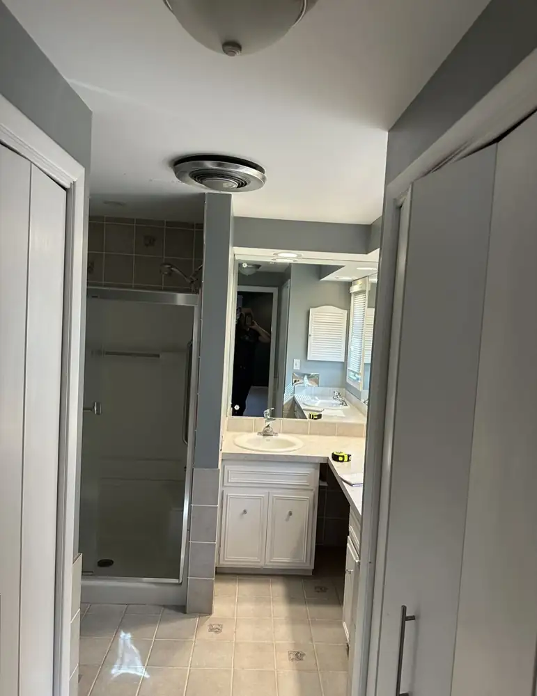 Primary bathroom with fiberglass shower and dated vanity before remodel, Beachwood, Ohio