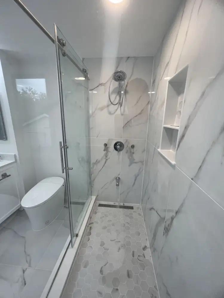 Another view: Primary bathroom with freestanding tub, glass shower, double vanity and marble-look porcelain, Beachwood, Ohio