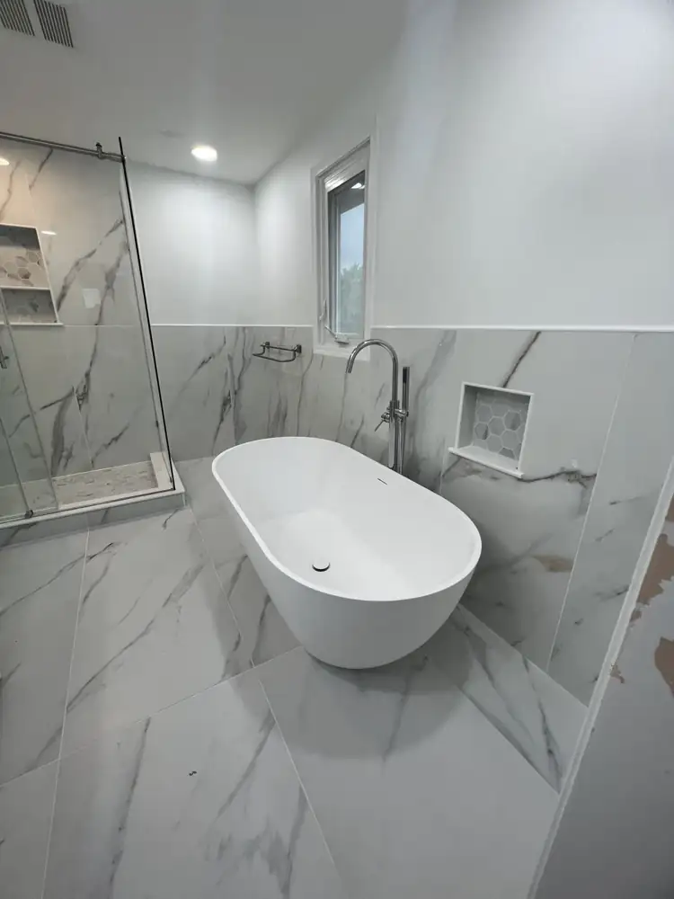 Another view: Primary bathroom with freestanding tub, glass shower, double vanity and marble-look porcelain, Beachwood, Ohio