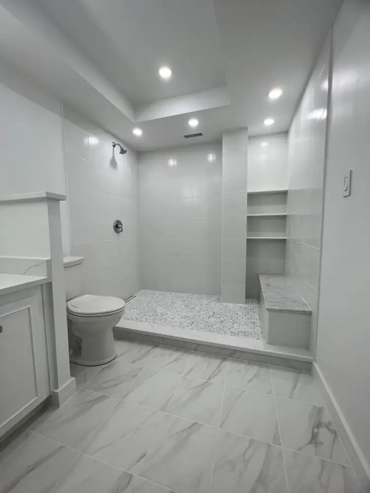 Bright white bathroom with walk-in shower, marble mosaic floor, bench and built-in shelves, Bratenahl, Ohio