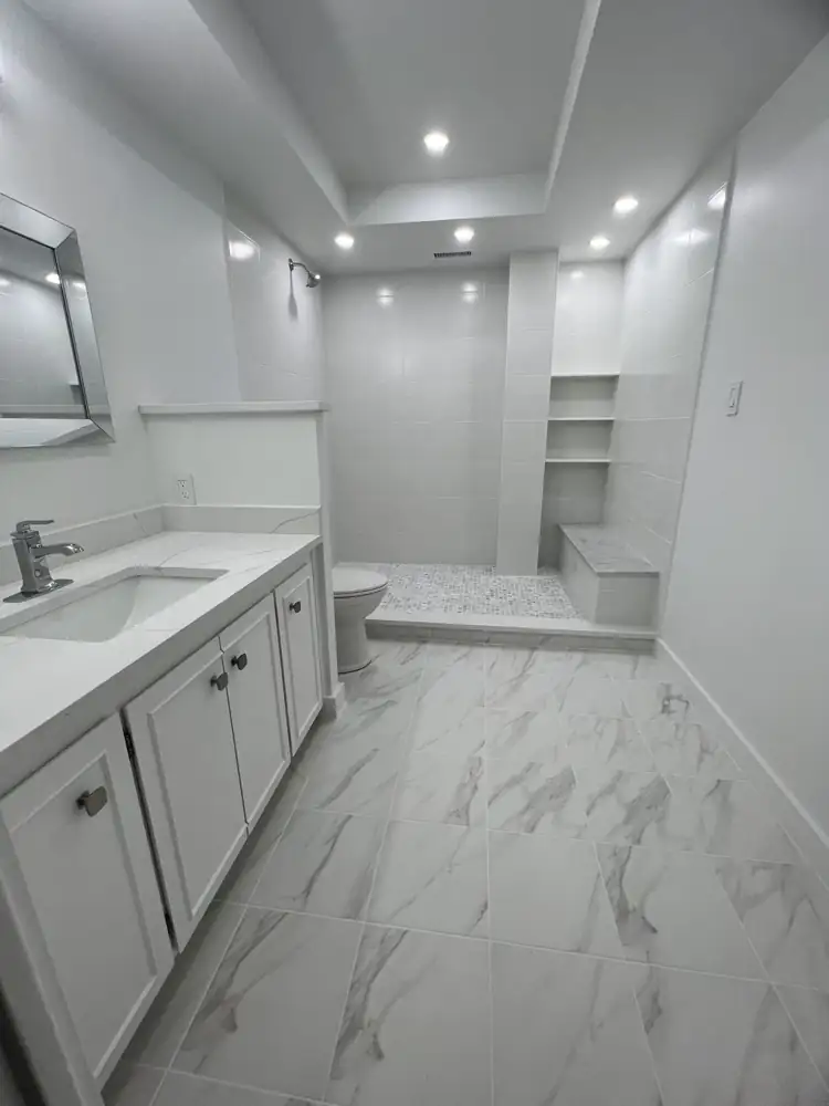 Another view: Bright white bathroom with walk-in shower, marble mosaic floor, bench and built-in shelves, Bratenahl, Ohio