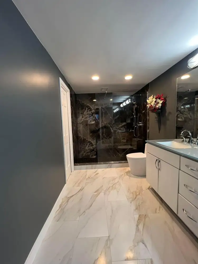 Another view: Walk-in shower with dark marble-look porcelain, glass panel and grab bar, gold-veined floor tile, Bratenahl, Ohio
