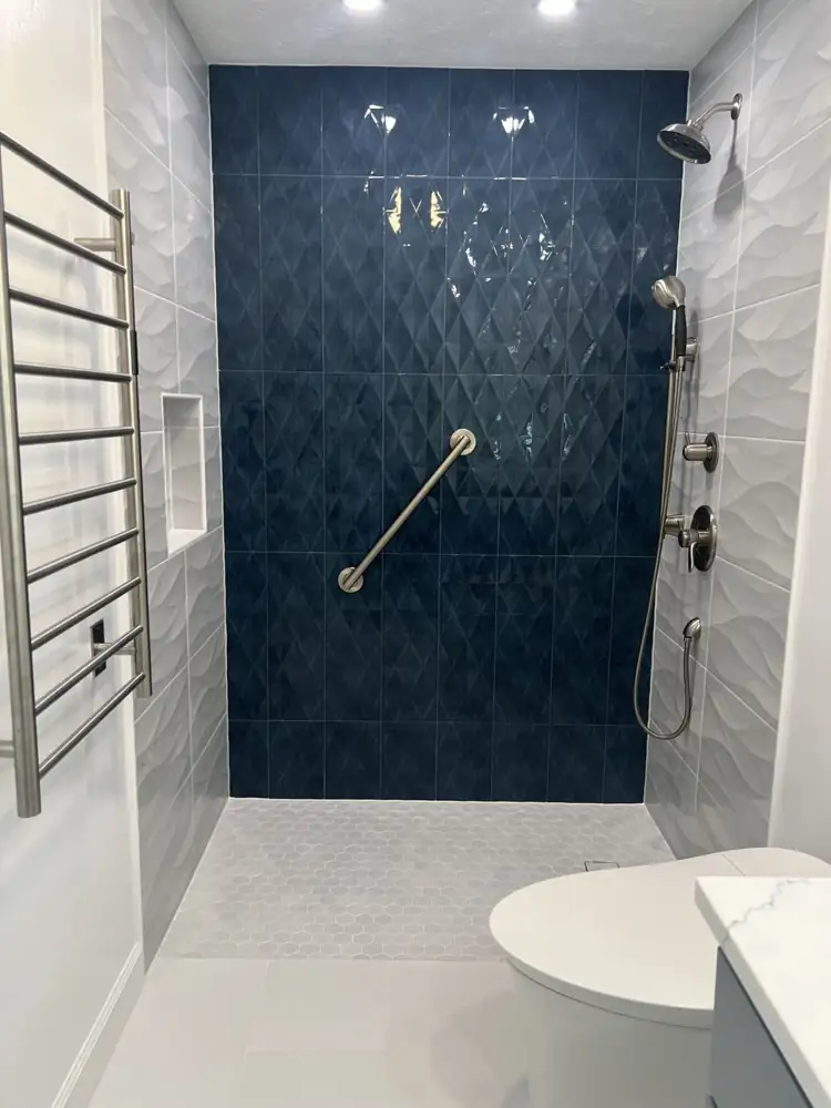 Curbless walk-in shower with navy diamond tile wall, grab bar and handheld shower, Brecksville, Ohio