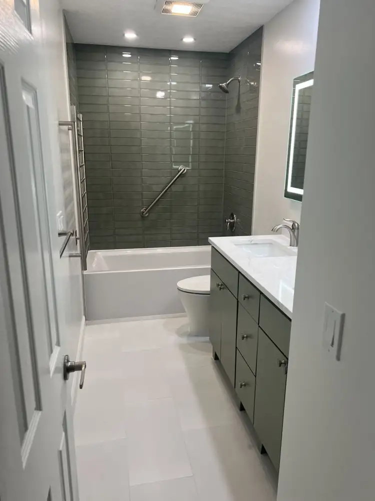 Another view: Dated teal bathroom with fiberglass tub and green laminate vanity before remodel, Brecksville, Ohio