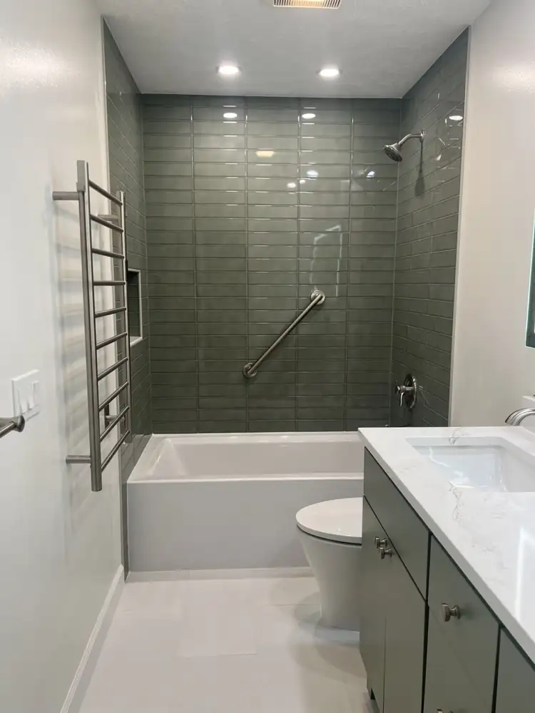 Another view: Dated teal bathroom with fiberglass tub and green laminate vanity before remodel, Brecksville, Ohio