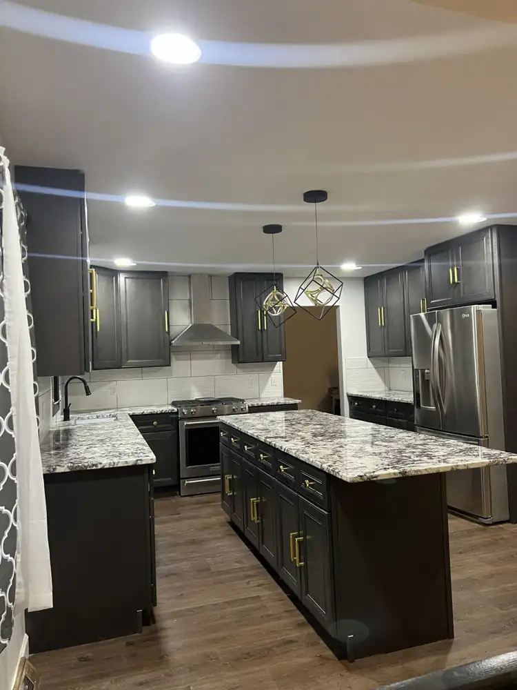 New kitchen with dark cabinets, brass pulls, granite counters, large island and luxury vinyl plank floor, Beachwood, Ohio