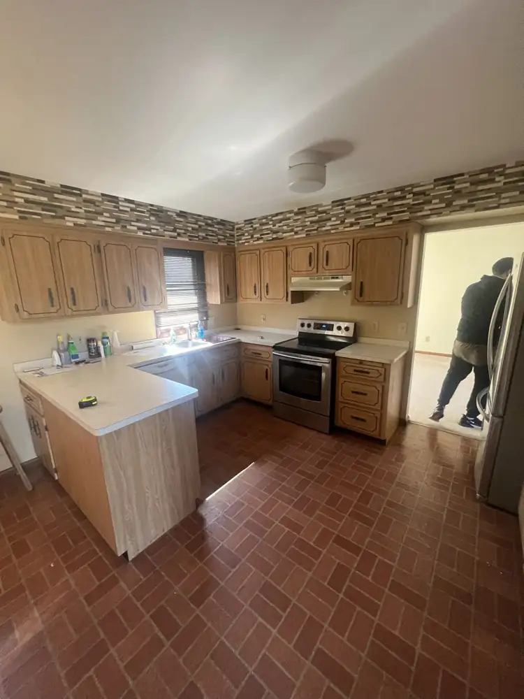 Dated oak kitchen with laminate counters and brick-pattern floor before remodel, Beachwood, Ohio