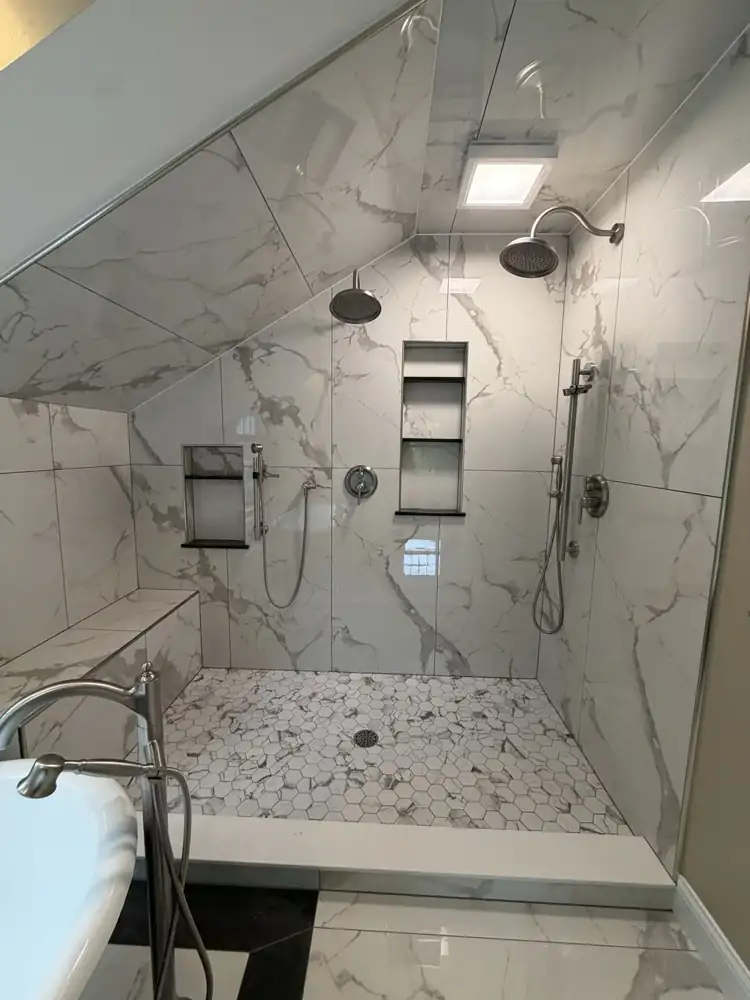 Double walk-in shower under a sloped ceiling with marble-look porcelain, two rain heads, two handhelds and niches, Ohio