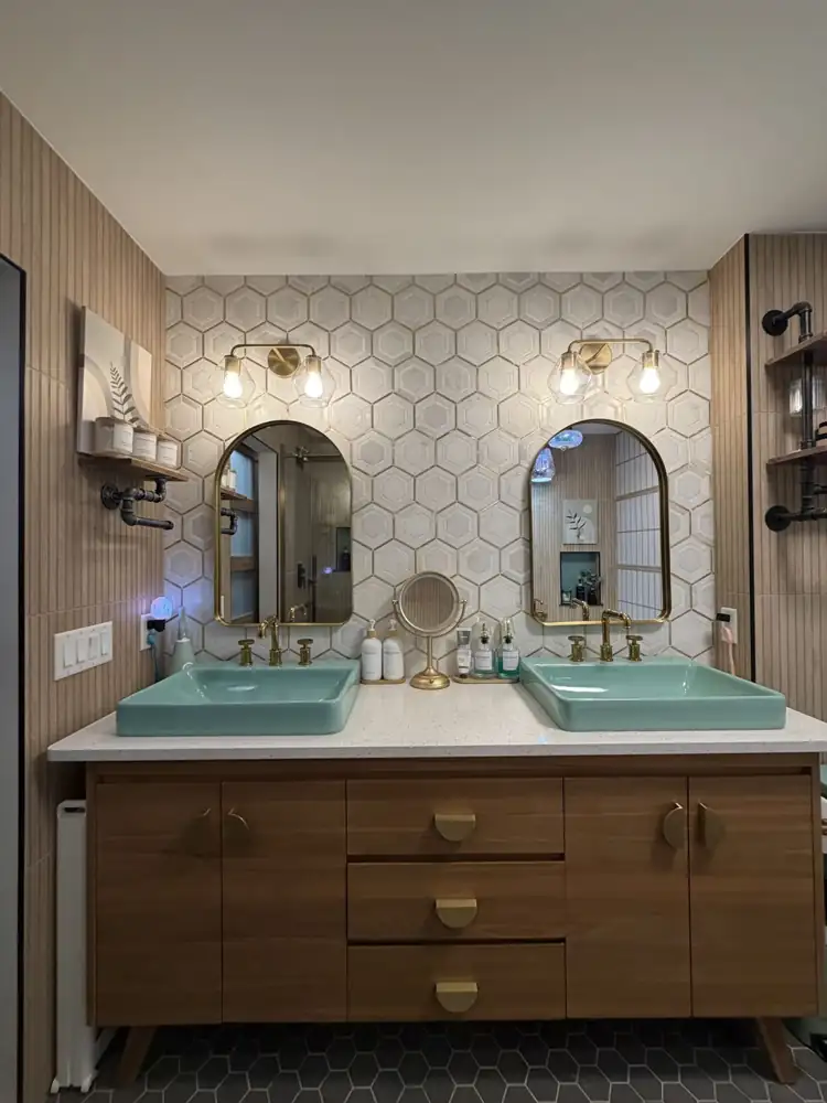 Walnut double vanity with turquoise sinks, brass faucets, arched brass mirrors and 3D hexagon tile wall, Ohio