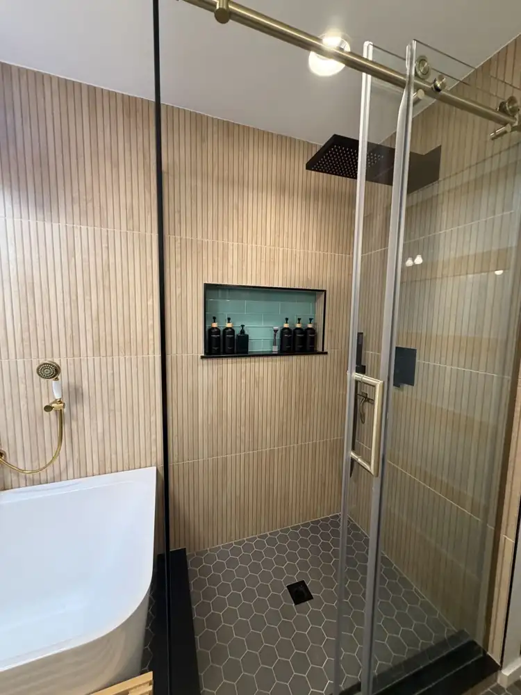Another view: Bathroom with shoji-style tile wall, freestanding tub, glass shower with fluted wood-look tile, hex floor and turquoise fixtures, Chagrin Falls, Ohio