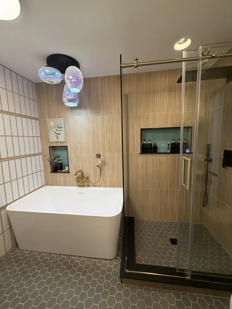 Another view: Bathroom with shoji-style tile wall, freestanding tub, glass shower with fluted wood-look tile, hex floor and turquoise fixtures, Chagrin Falls, Ohio