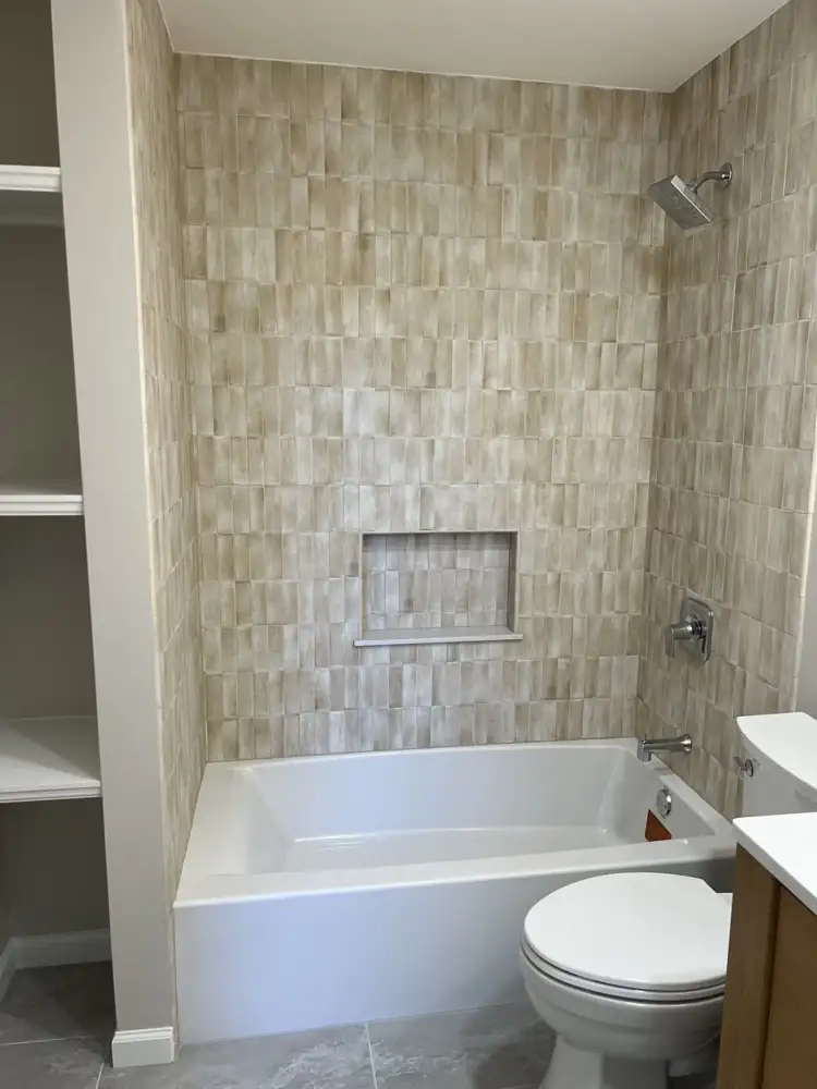 New soaking tub with handmade-look stacked tile surround and tiled niche