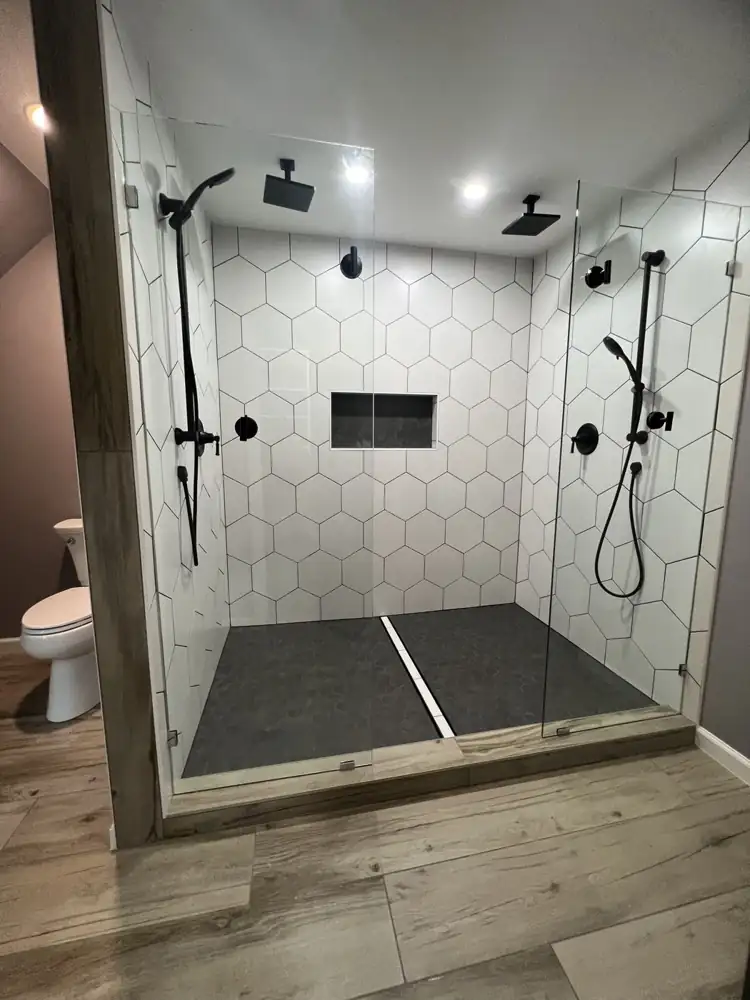 Double walk-in shower with white hexagon tile, black fixtures, two rain heads and linear drain, Hudson, Ohio