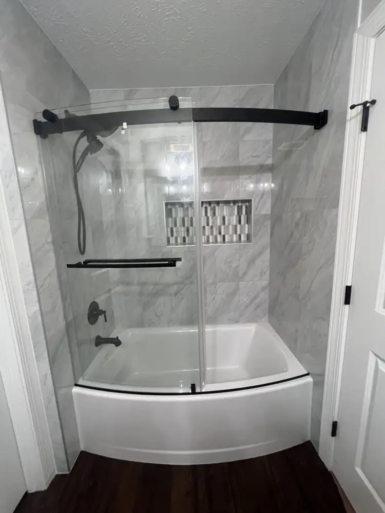 Another view: New tub with marble-look porcelain surround, curved sliding glass door and matte black fixtures, Macedonia, Ohio