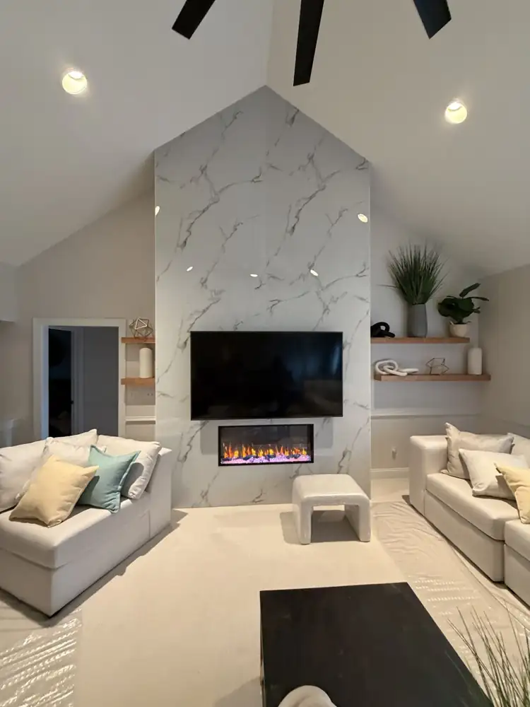Living room with floor-to-ceiling porcelain fireplace wall remodeled by Lux Home Remodeling in Macedonia