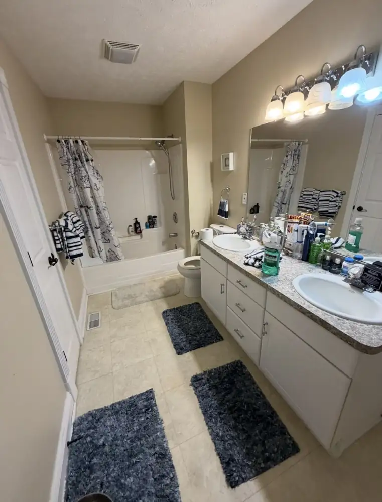 Hall bathroom with fiberglass tub, shower curtain and laminate vanity before remodel, Mentor, Ohio