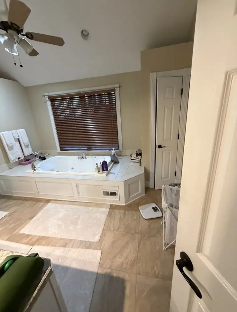 Primary bathroom with tiled jetted tub platform and beige tile before remodel, Mentor, Ohio