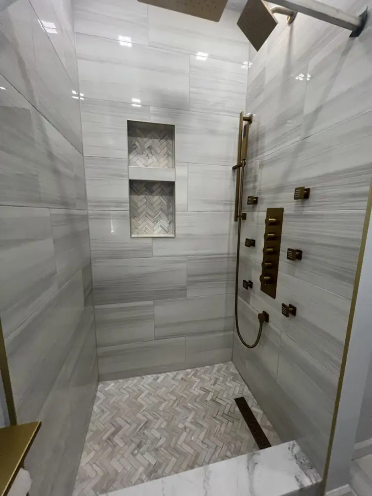 Walk-in shower with brushed gold body jets, dual rain heads, thermostatic panel, herringbone floor and niches, Ohio
