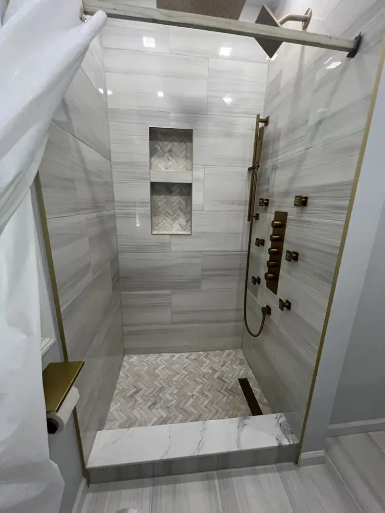 Another view: Small bathroom with white vanity, large-format gray porcelain floor, new window trim and brushed gold accessories, Mentor, Ohio