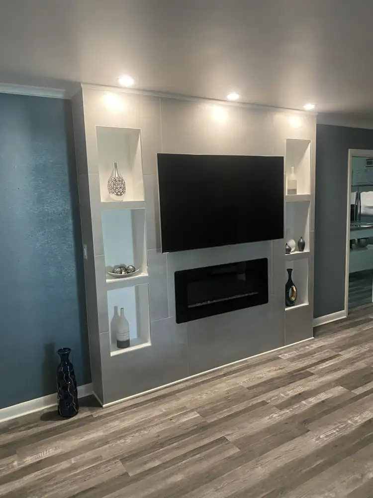 Floor-to-ceiling gray porcelain media wall with electric fireplace, mounted TV and six lit display niches, Northeast Ohio