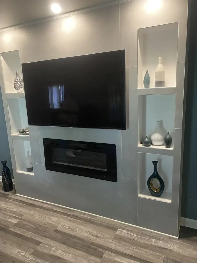 Porcelain tile media wall with linear electric fireplace and white display niches over luxury vinyl plank floor, Northeast Ohio