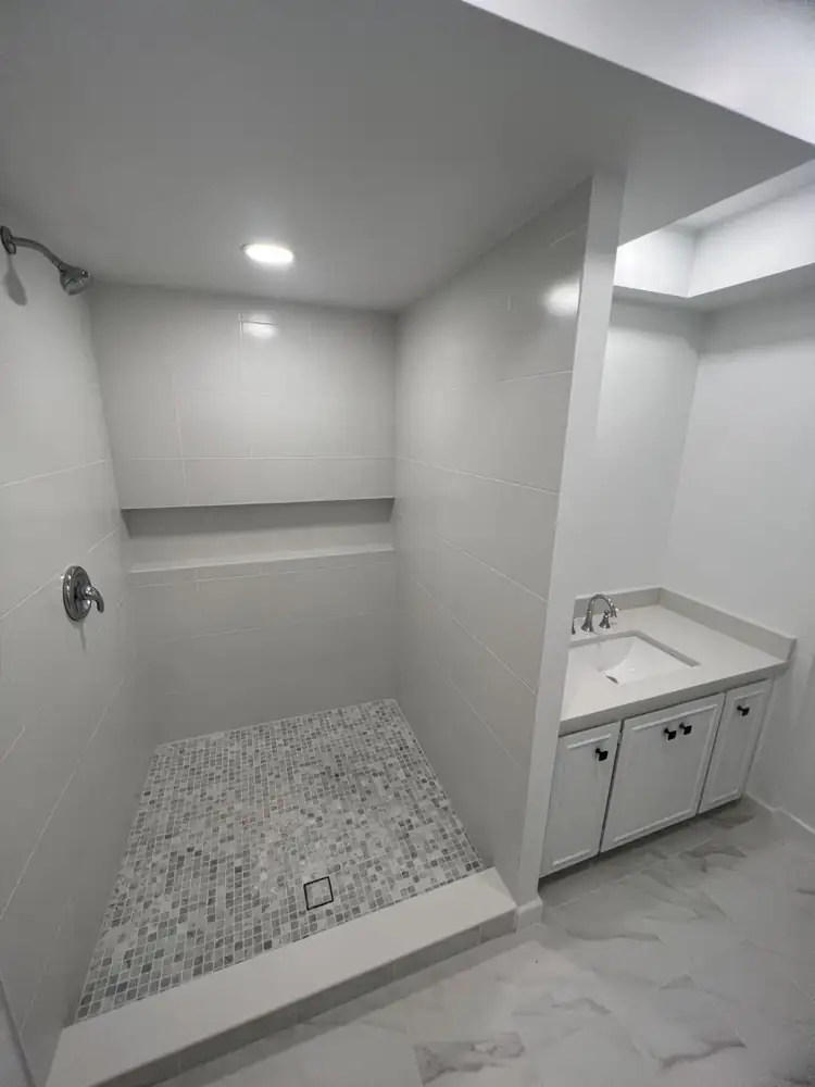 Bathroom with white tile walk-in shower and white vanity with quartz top, Northeast Ohio