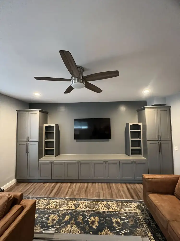 Custom built-in gray shaker media wall with tall pantry cabinets, open shelves and mounted TV, Northeast Ohio