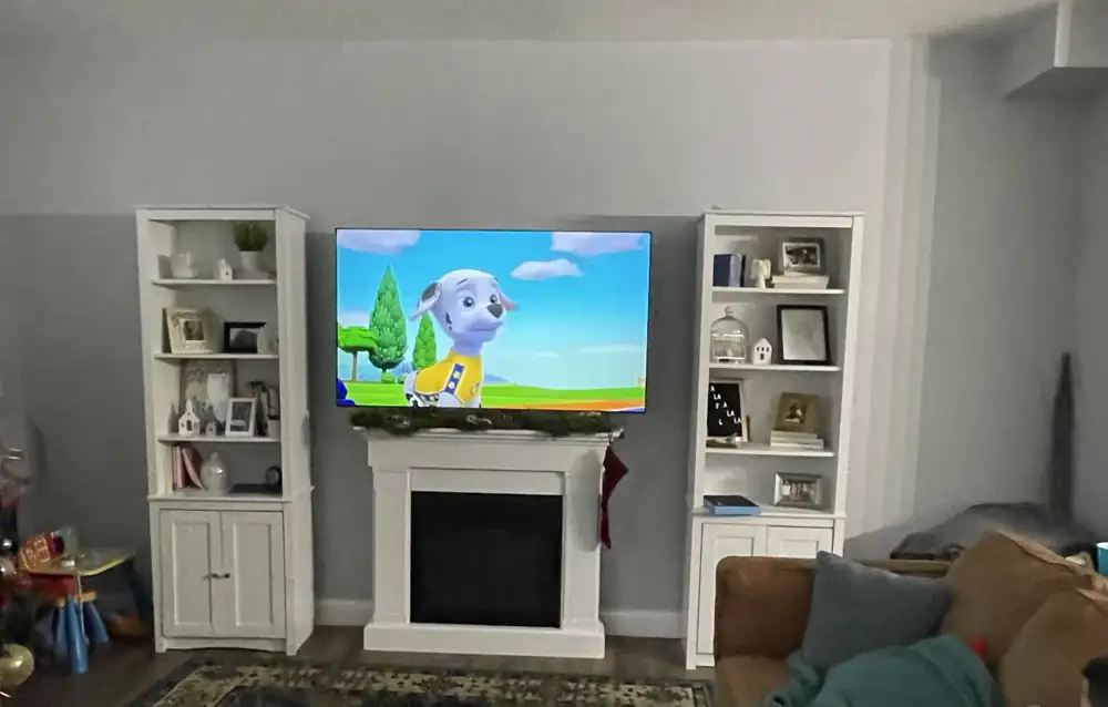 Living room TV wall with freestanding bookcases and faux fireplace before built-ins, Northeast Ohio