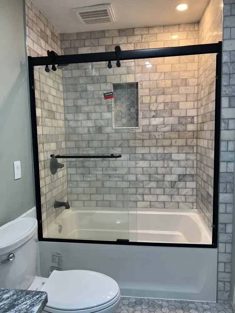 Tub and shower with white marble subway tile, hex mosaic niche and oil-rubbed bronze fixtures, Northeast Ohio