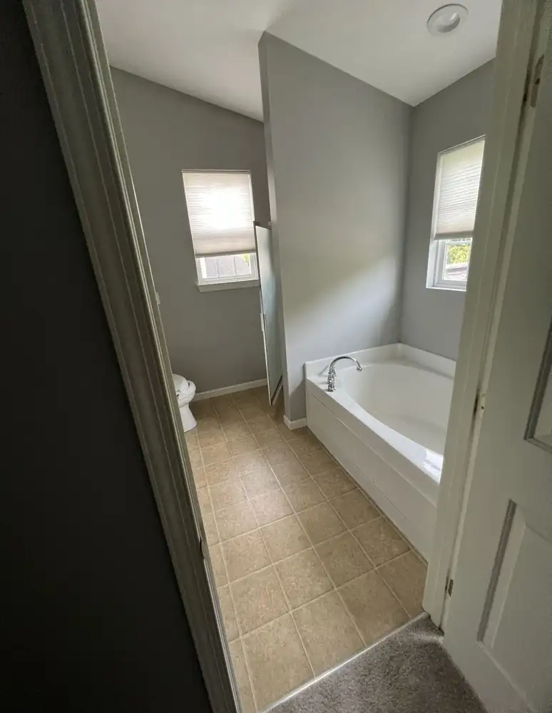 Primary bathroom with corner garden tub and vinyl floor before remodel, Northeast Ohio