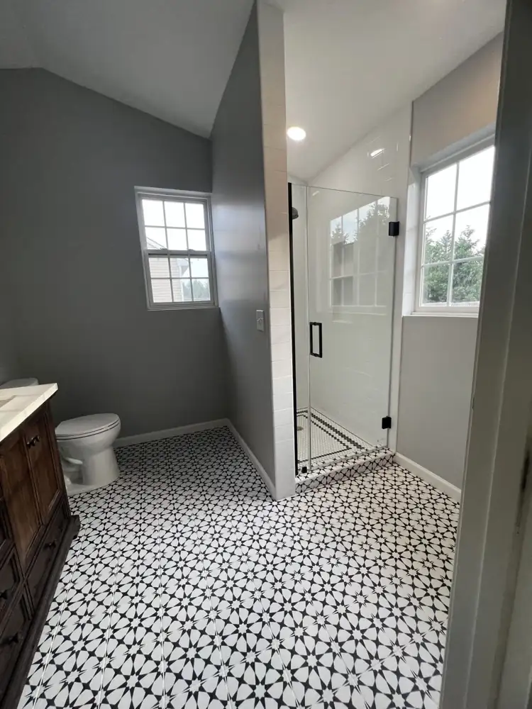 White subway tile walk-in shower with frameless glass door and black hardware, Northeast Ohio
