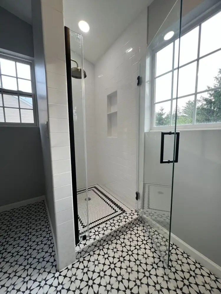 Shower with white subway tile, hexagon mosaic floor with black border and built-in niche, Northeast Ohio