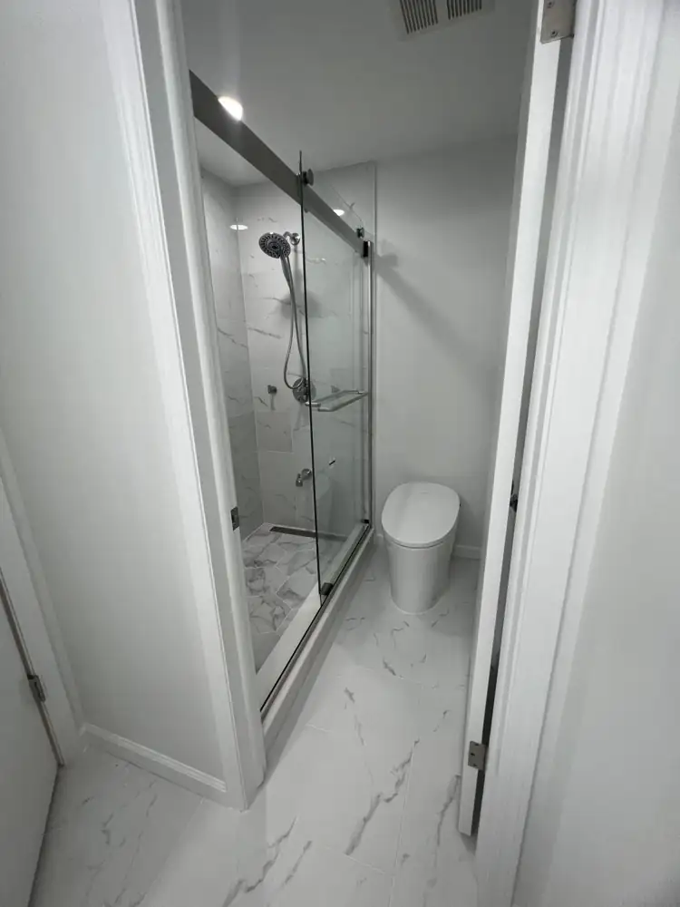 Small bathroom with marble-look porcelain walk-in shower, sliding glass door and smart toilet, Northeast Ohio