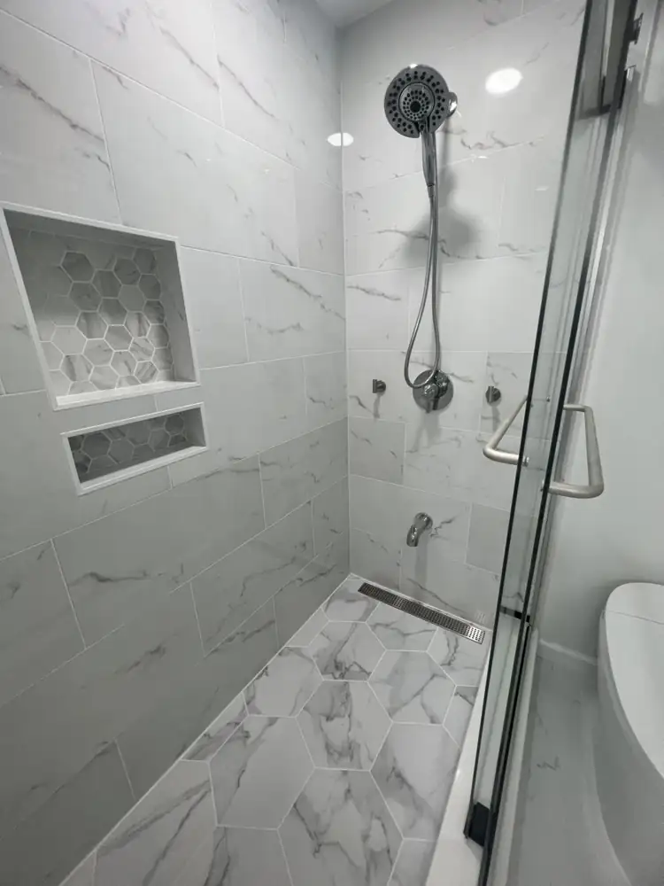 Walk-in shower with marble-look tile, hexagon floor, linear drain and two niches, Northeast Ohio