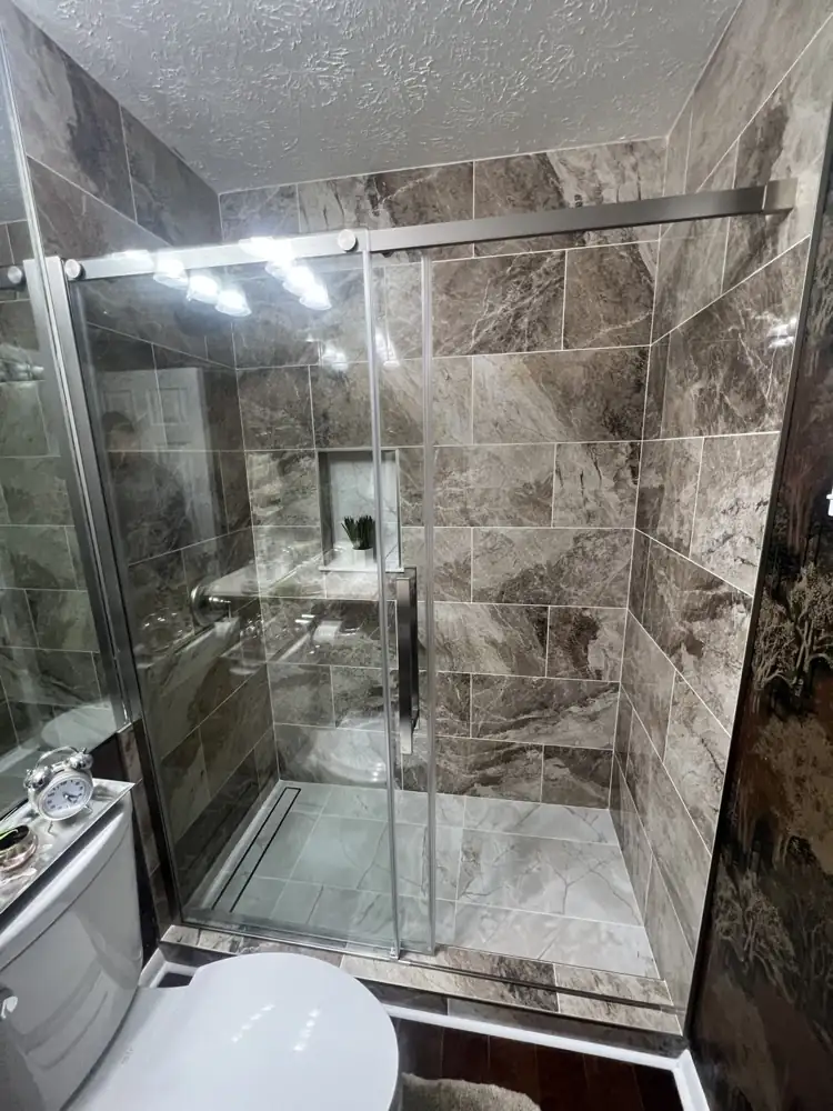Walk-in shower with brown marble-look porcelain, sliding glass door, linear drain and niche, Northeast Ohio