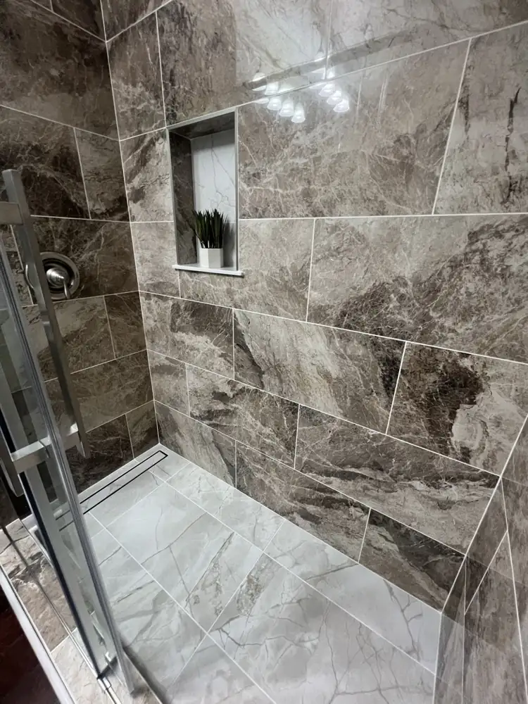 Brown and gray marble-look porcelain shower walls with light gray tile floor and recessed niche, Northeast Ohio