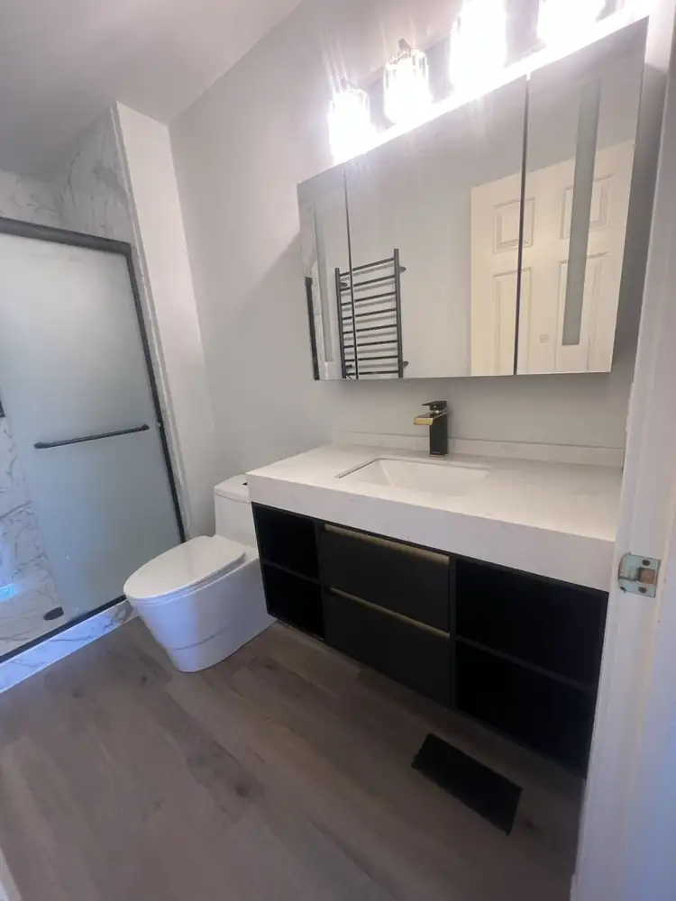 Black floating vanity with quartz top, black and gold faucet and lighted medicine cabinet, Northeast Ohio