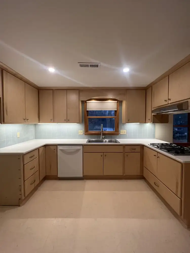 Kitchen with natural maple cabinets, white quartz countertops, blue glass tile backsplash and under-cabinet lighting, Northeast Ohio