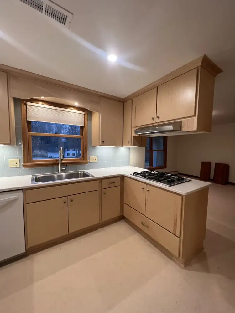 Maple kitchen peninsula with gas cooktop, quartz counters and arched valance over the sink, Northeast Ohio