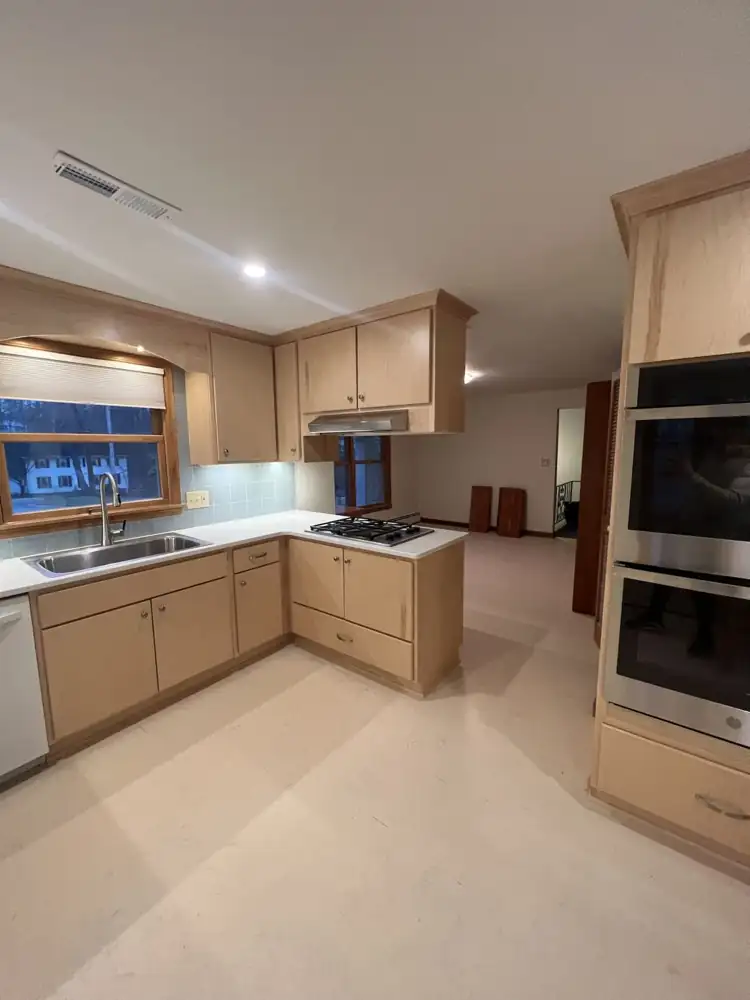 Maple kitchen open to the dining area with wall ovens and gas cooktop peninsula, Northeast Ohio